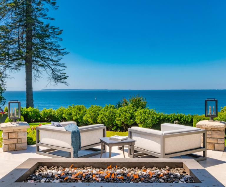 Vue panoramique sur la mer depuis une terrasse de maison de vacances, illustrant le rêve : acheter une résidence secondaire en bord de mer.