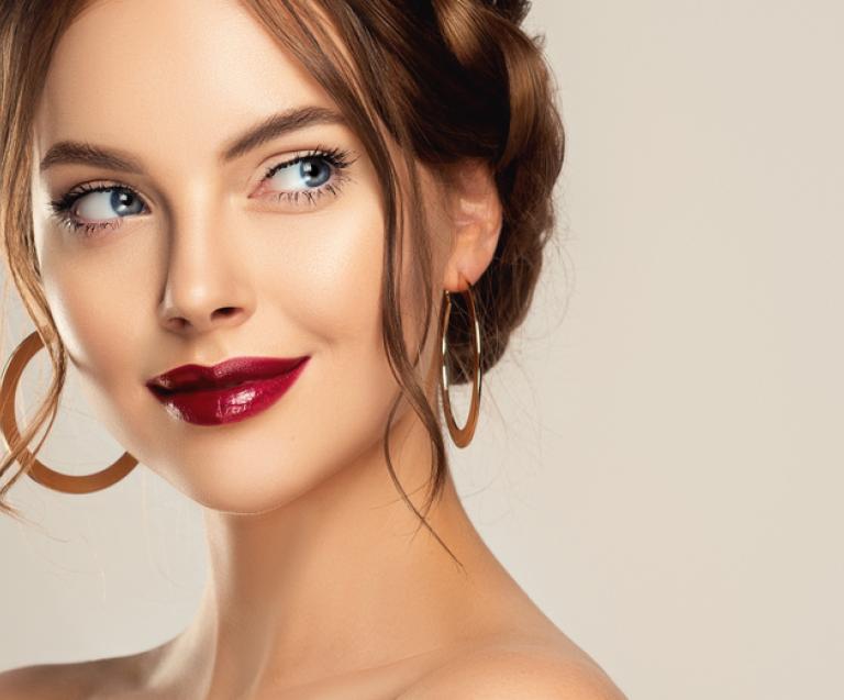 Portrait d’une femme élégante portant des boucles d’oreilles inspirées de la joaillerie Zolotas