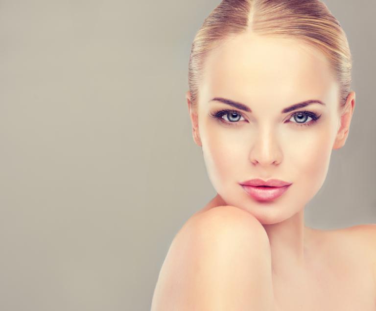 Portrait d’une femme au teint parfait illustrant les standards esthétiques et les innovations de la beauté du futur.