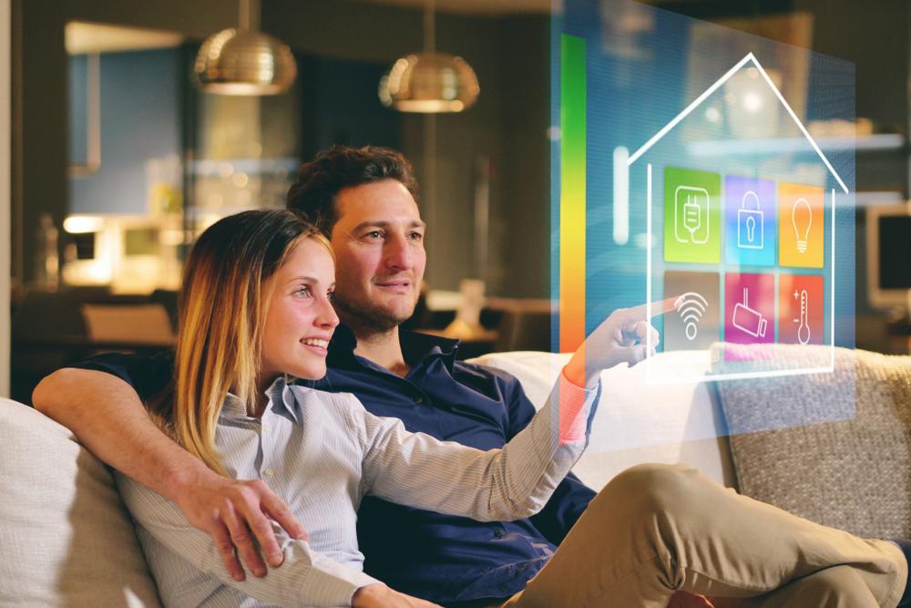 Couple utilisant les fonctionnalités d'un appartement connecté depuis leur salon intelligent