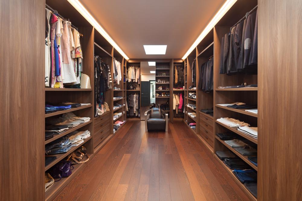 Dressing de luxe en bois avec aménagement sur mesure, éclairage intégré et mobilier haut de gamme pour une résidence d’exception