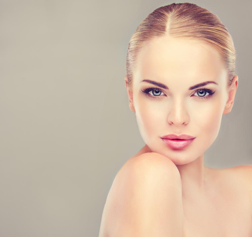 Portrait d’une femme au teint parfait illustrant les standards esthétiques et les innovations de la beauté du futur.