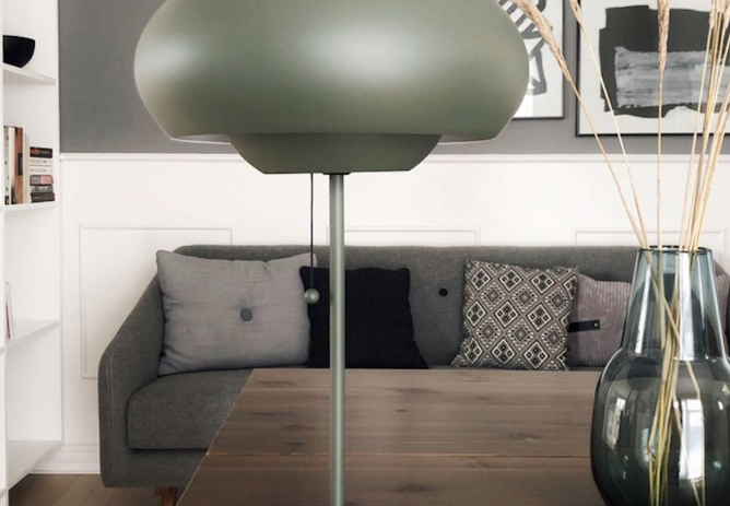 Lampe mushroom design vert kaki posée sur une table en bois dans un salon moderne