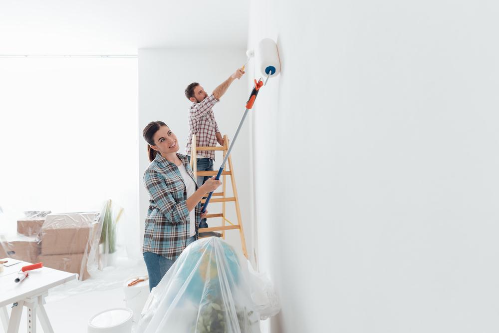 Un couple réalise des travaux de peinture dans un logement loué – illustration des travaux en location partagés entre bailleur et locataire